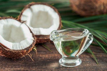 Liquid coconut MCT oil and halved coco-nut on wooden table. Health Benefits of MCT Oil. MCT or medium-chain triglycerides, form of saturated fatty acid.